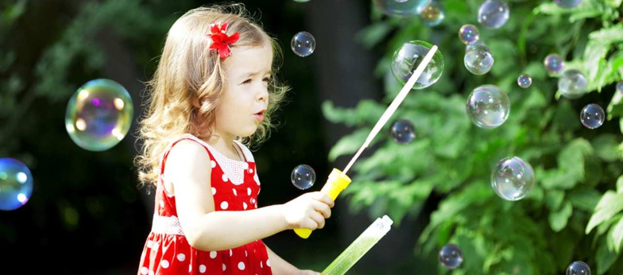 Foto de niños jugando pompas de jabón.