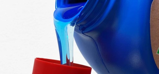 Detergente líquido que fluye del vaso a una tapa