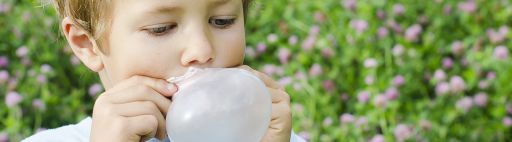 Niño inflando un globo