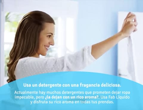 Mujer sonriente y vestida de blanco mira una prenda que sostiene en sus manos