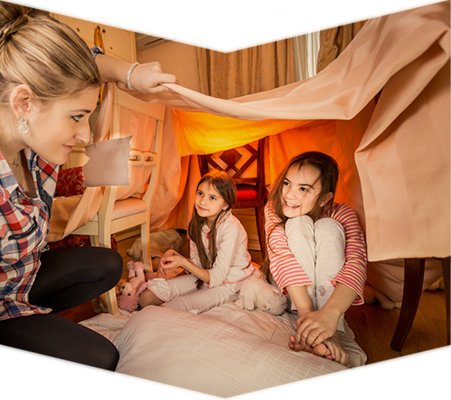 Dos niñas hacen un camping en su casa mientras su mama las mira