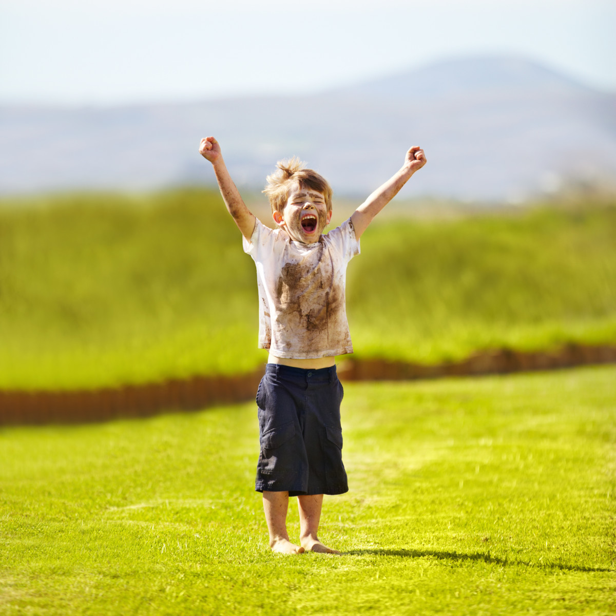 niño feliz lleno de barro