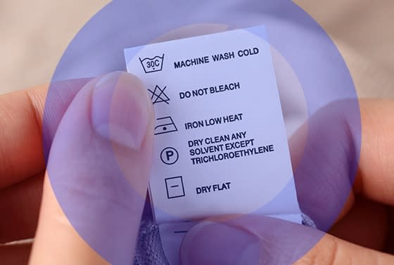 Etiqueta con instrucciones de lavado dentro de un circulo purpura