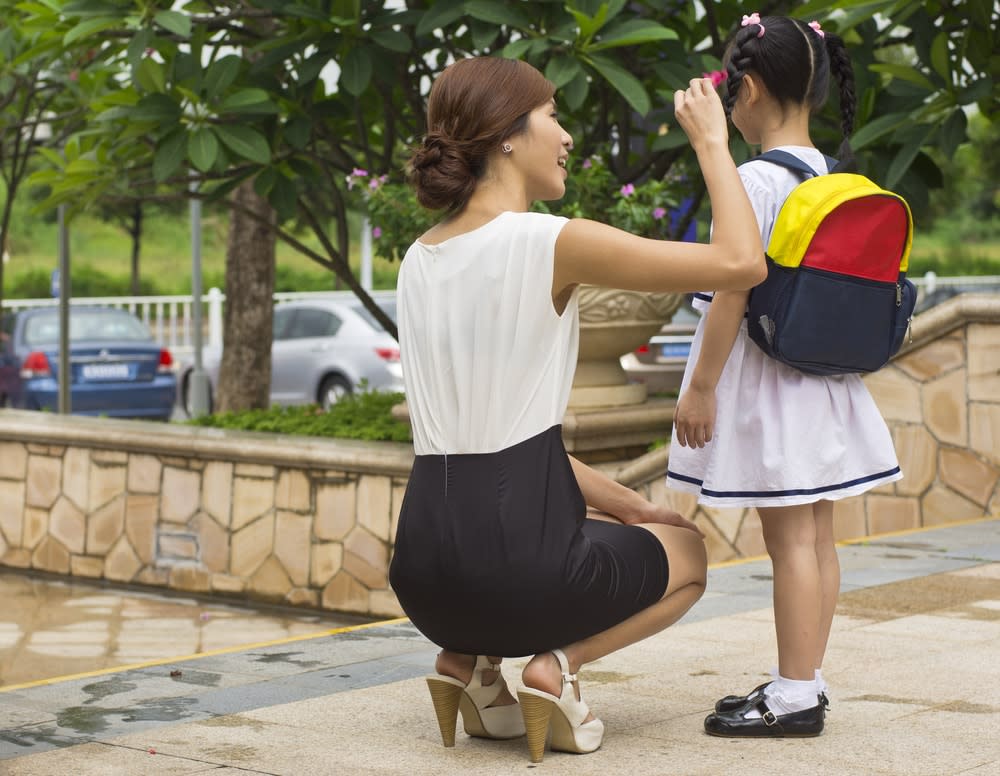 Niña yendo a la escuela con la madre
